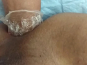 A sissy in a solo scene, crossdressed and enjoying anal sex with a fist.