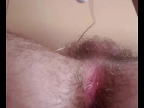 Young gay man pleasures himself by stimulating his anus with his finger and a vibrator.