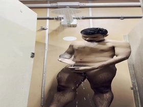 A hot young gay guy takes a shower outside on the sidewalk.