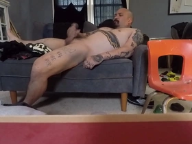 A solo boy plays with his cock on the couch in the nude.